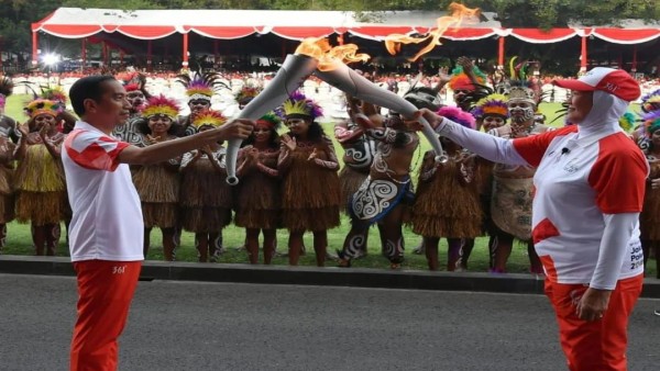 Verawaty Fajrin (kanan) menyerahkan api kepada Presiden Joko Widodo (Jokowi) dalam pawai obor Asian Games 2018-1637481522