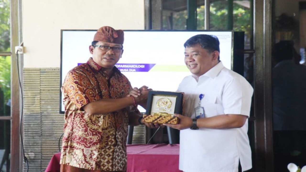 Anggota Komisi IV DPR RI I Made Urip (kiri) saat bertukar cinderamata usai meninjau Turtle Conservation and Educatoin Center (TCEC) di Pantai Serangan, Kota Denpasar, Bali, Kamis (16/6/2022). (Arief/nvl)