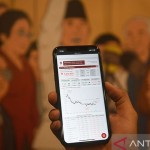 Ilustrasi - Pekerja memperlihatkan pergerakan Indeks Harga Saham Gabungan (IHSG) melalui gawainya di Jakarta. ANTARA FOTO/Puspa Perwitasari/foc/aa.-1668565799