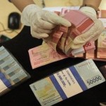 Petugas menghitung uang rupiah dan dolar AS-1668654367