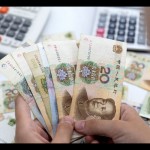 Ilustrasi - Wanita memegang uang kertas Yuan China. ANTARA/REUTERS/Dado Ruvic/aa.-1670815735