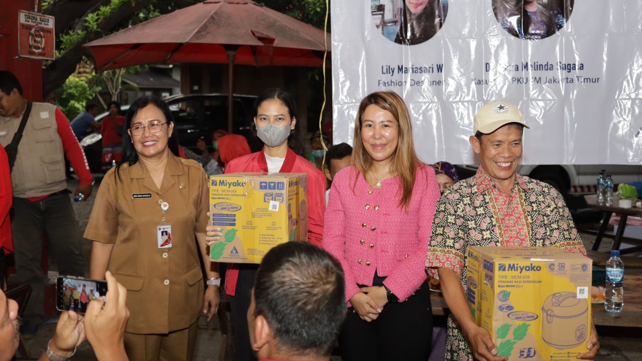 Sondang Tampubolon saat menyerahkan hadiah dan bantuan bagi masyarakat peserta sosialisasi Kemendag RI. (Mario Sijabat)