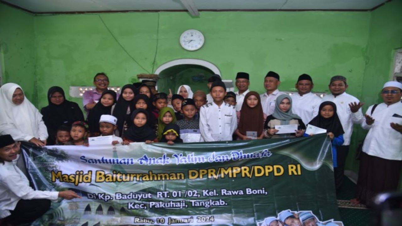 Ketua DKM Masjid Baiturrahman DPR RI, Suratna dalam foto bersama usai menggelar santunan dan pemberian zakat sedekah kepada yatim piatu dan kaum duafa di Kabupaten Tangerang, Banten. Foto: Kresno/nr