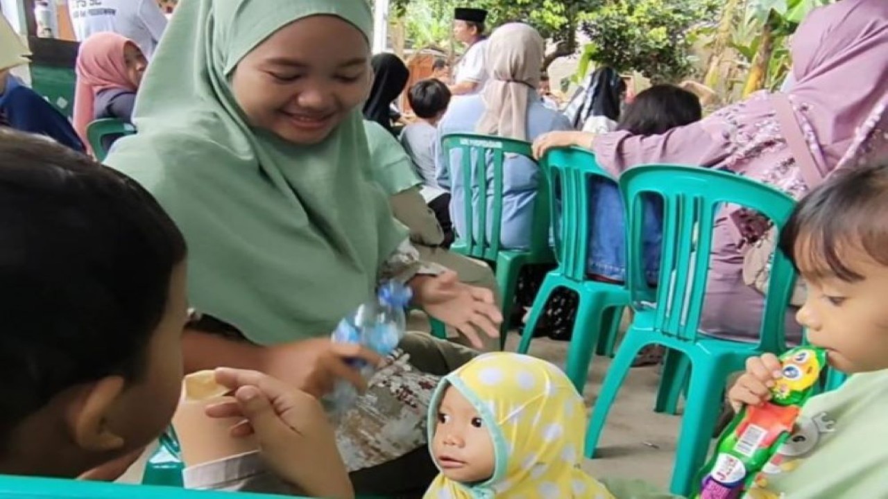 Ibu Putri dan anak-anaknya antusias dengan suasana Pemilu 2024 di TPS 52 Pedurenan, Kota Bekasi, Rabu (14/2/2024). Foto: Ayu/nr