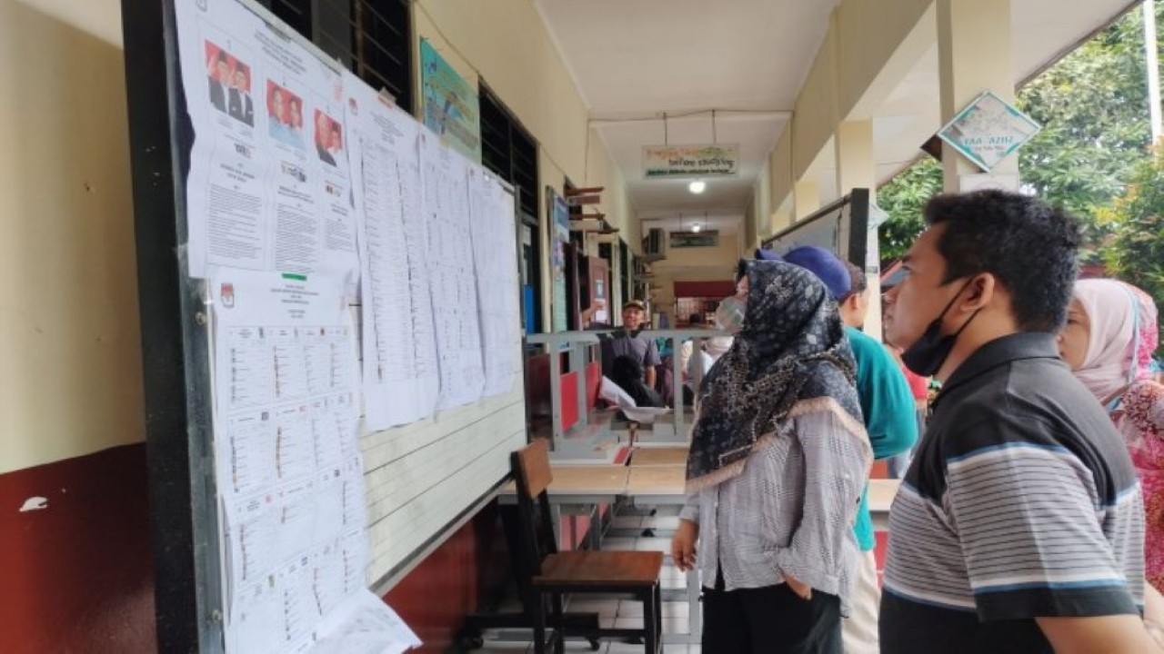 Beberapa warga saat sedang melihat beberapa contoh surat suara yang akan dipilih pada Pemilu 2024 di TPS 22 Kelurahan Mekarsari, Cimanggis, Depok. Foto: Hira/nr