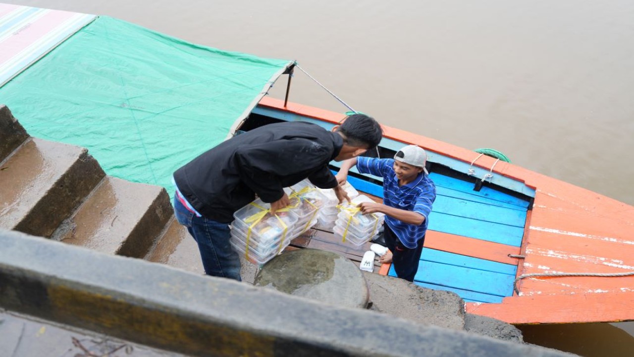 Tim Satuan Pelayanan Pemenuhan Gizi (SPPG) Gandus setiap hari menembus ombak mengantar MBG. (Istimewa)