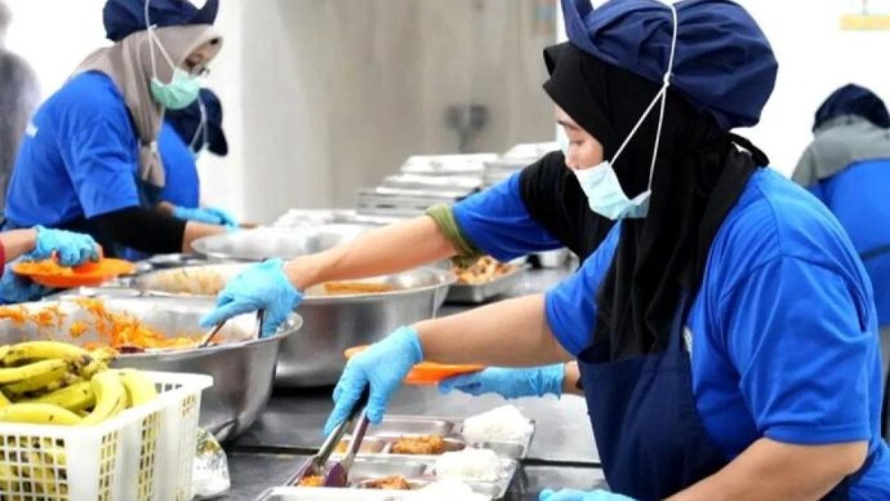 Petugas di SPPG tengah menyiapkan Makan Bergizi Gratis (MBG) untuk diberikan kepada penerima manfaat. ANTARA/HO-BGN/aa. (Antara)